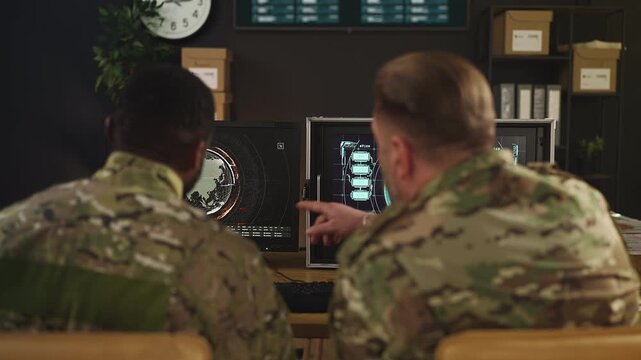 Military officers discussing surveillance data inside air defense command center