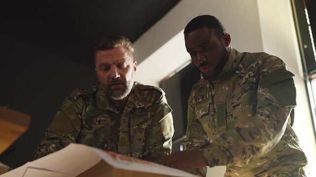 Military officers developing secret operation strategy using topographic maps