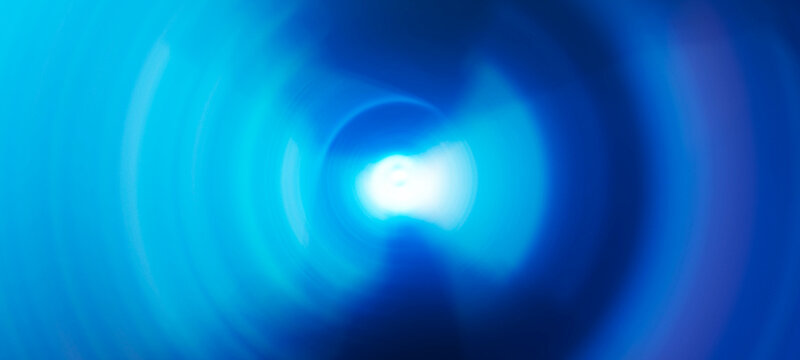 Abstract circular light tunnel with bright glow in center creating vortex effect and futuristic energy portal.