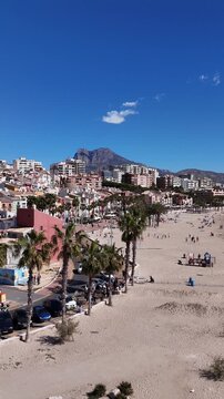 Vertical drone descending over Villajoyosa coastline and colorful houses
