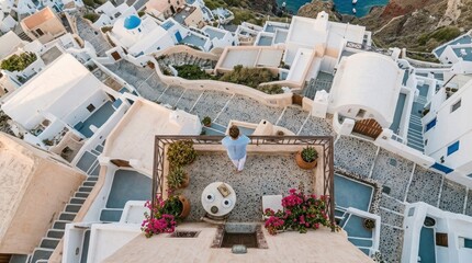 Obraz premium Woman overlooking Santorini village rooftops aerial view