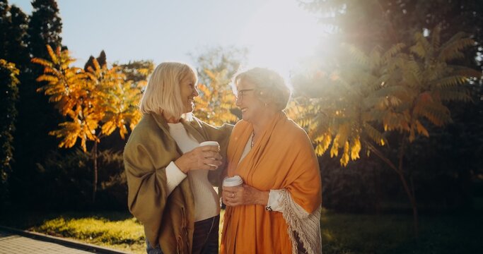 Senior friends enjoying autumn day with coffee