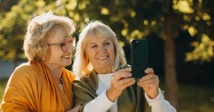 Senior women friends enjoying a moment capturing memories