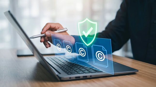 Digital copyright protection concept, person using laptop with virtual shield icon and document symbols