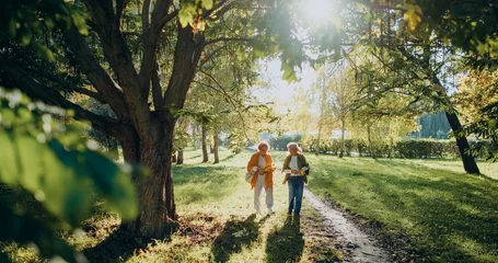 Fotobehang Waterval Senior women walking in park enjoying autumn nature  © dsheremeta