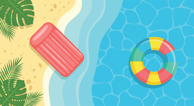 Top view of a tropical sandy beach with an inflatable pink mattress and a colorful swim ring floating in blue water.