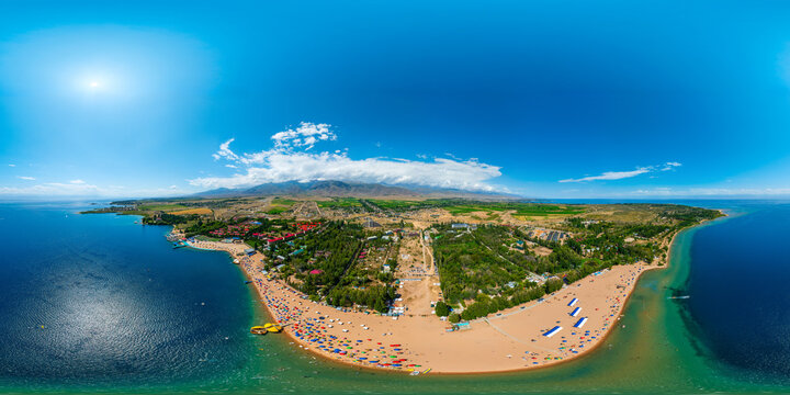 Aerial 360 degrees view of crowded sandy beach at Issyk-Kul lake in equirectangular projection.