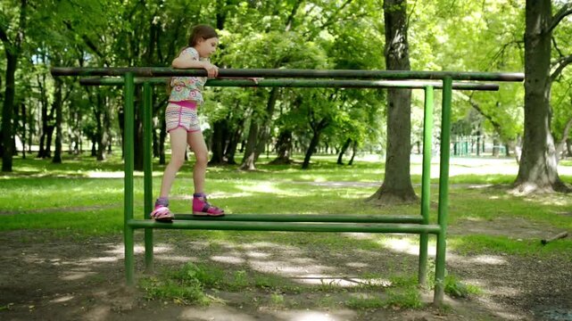 Two little girls are engaged on sports uneven bars