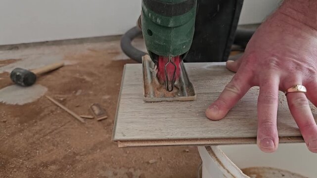 Cutting wood tile for home renovation project in workshop with hand tools and saw equipment