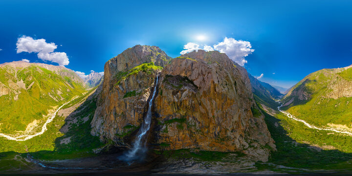 360 aerial panorama of Majestic Waterfall Cascading Down Craggy Mountains