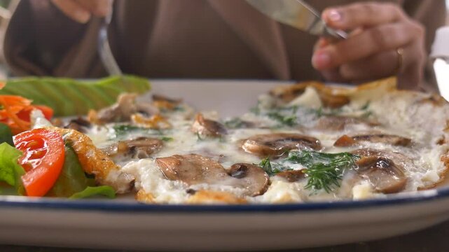 Eating a delicious dish with mushrooms omlet and chicken