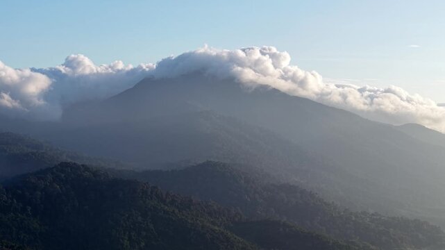 Misty peaks rise above forested slopes