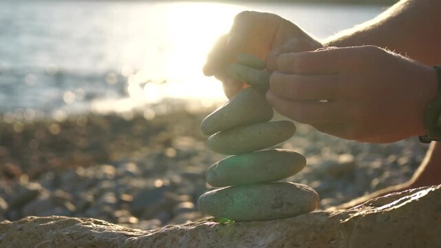 Building a Stone Cairn on a Beach at Sunset
