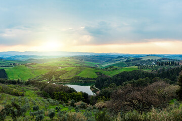 Naklejka premium Tuscany hills landscape with lake at sunset in Castelfalfi