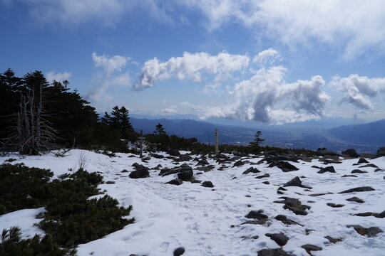 A quiet winter mountain landscape photographed in late February around Mount Amigasa and Nishidake in the southern Yatsugatake range, spanning Fujimi Town in Nagano Prefecture and Hokuto City in Yaman