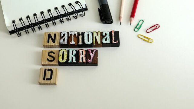 National Sorry Day Text on Wooden Blocks with Office Supplies Flat Lay