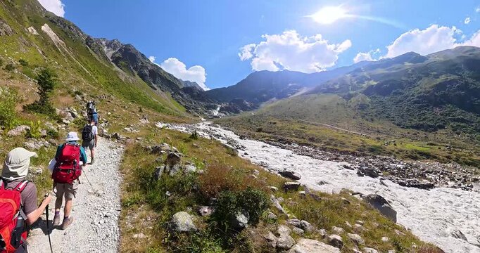 Hiking group ascending beside Pitztal waterfall in Alps Austria