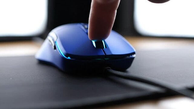 Close-up of a blue gaming mouse being clicked repeatedly on a mousepad