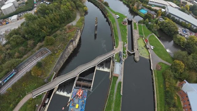 Aerial Lock View Leeds United Kingdom Showing Lock Gates, Maintenance Barge With Crane, Sluice Flow, Concrete Chambers And Adjacent Towpath, Technical Repair Atmosphere And Water Turbulence