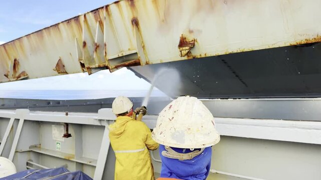 deck crew of cargo ship make washing of holds. team work. job and life of seafarers