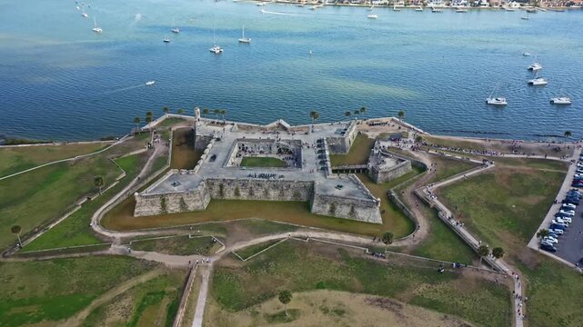 The star-shaped Castillo de San Marcos stands prominently by the waterfront, with boats dotting the water. Ideal for historical documentaries and travel features.