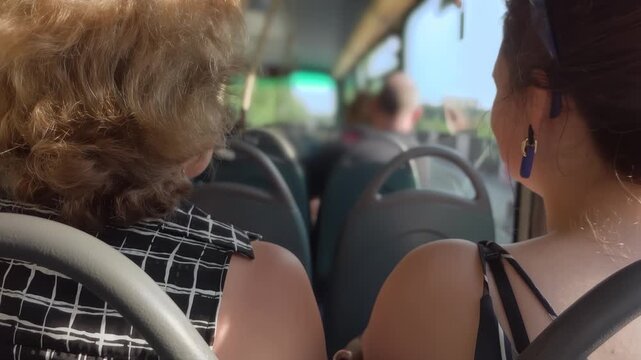 Women riding on the upper deck of a city bus in Liverpool. Urban travel sightseeing double decker.