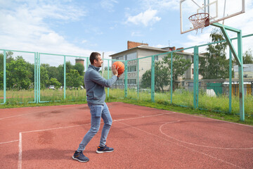 Fototapeta premium Man playing ball at the outdoor basketball court