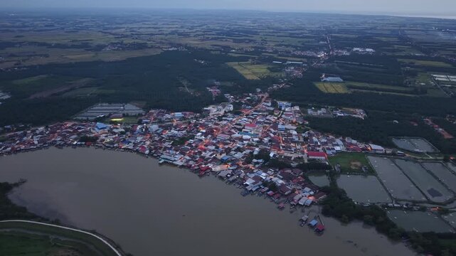 Drone footage shows Sungai Udang village along river at night with lights and surrounding farmland.