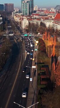 Modern city transportation system drone view traffic bridge sunset. Urban infrastructure commute public tram railway passenger car congestion high angle perspective. Golden hour sunlight 