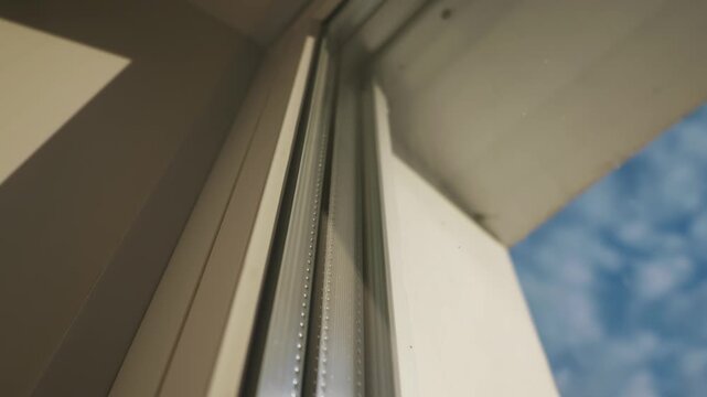Detailed close-up of a modern triple glazed window frame showing metal spacer bars and glass panes. Concept of energy efficiency, home insulation, sustainable building, and heat conservation.