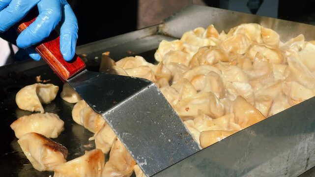 At a Chinese market, they prepare shui jiao, dumplings with a juicy filling of meat, seafood, or vegetables. The concept is Chinese cuisine. High quality 4k footage