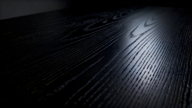Modern dark black ebony wood grain texture background with sleek linear patterns.