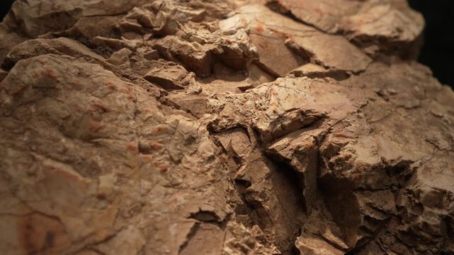 Close-up layered rock formation with dry cracked earthy texture