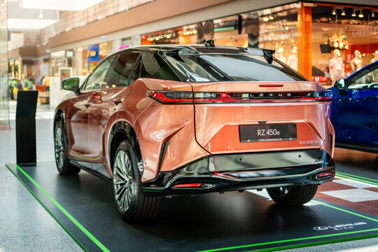 Brno, Czech Republic - June 22, 2025: Rear view of a modern electric car Lexus RZ 450e. Japanese premium SUV in orange color.