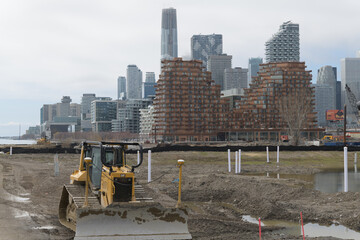 Naklejka premium redevelopment of land west of Cherry St with heavy equipment (Caterpillar bulldozer with a front blade) and view of city, Toronto 