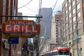 Naklejka premium vintage projecting neon sign outside Patrician Grill, a restaurant, located at 219 King St E, Toronto