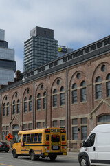 Obraz premium school bus outside the Bond & Smith designed Consumers’ Gas Station A at 51 Parliament St; now serving as 51 Division headquarters, Toronto, April 2026