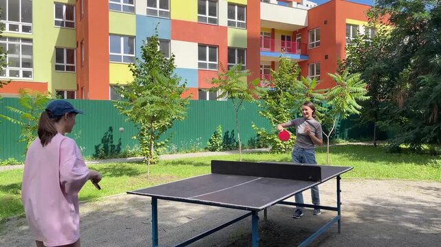 Outdoor sport - two Women Engage In Lively Table Tennis Game