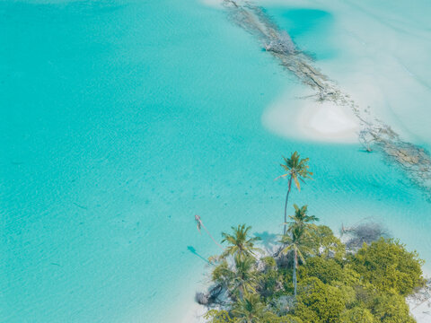 Aerial view of the tropical island's white sands meet the turquoise ocean, a serene escape under the equatorial sun, Thuraakunu, Thiladhunmathee Uthuruburi, Maldives.