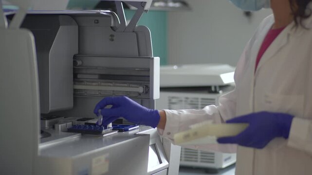 Laboratory Technician Loading Sample Tubes into Automated Clinical Analyzer