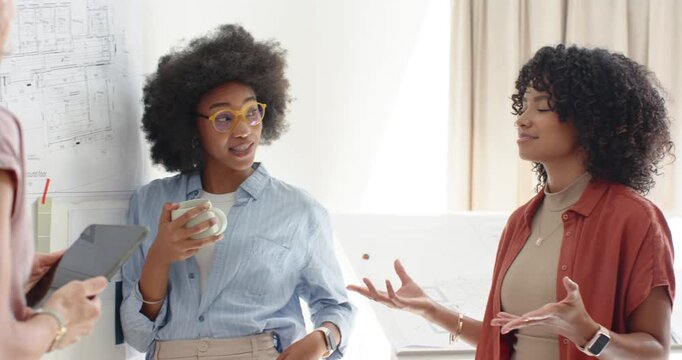 Diverse women in studio viewing tablet lead woman adjusting yellow glasses with mug, checking plans