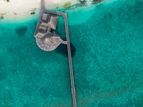 Aerial view of the vibrant turquoise waters contrast with the pristine white sands and thatched roof bungalows, Hoarafushi, Thiladhunmathee Uthuruburi, Maldives.