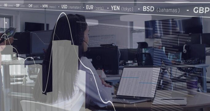 Typing female worker wearing white blouse working on laptop at open office, with currency ticker