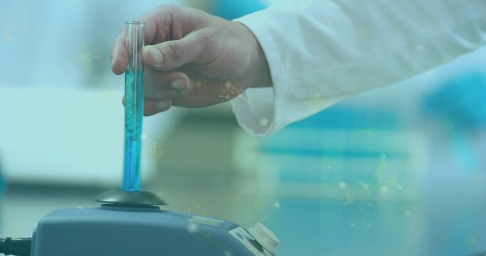Inserting lab-coated hand holding glass test tube into benchtop mixer, with bright blue solution