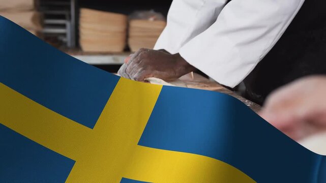 Swedish flag sweeping across foreground, revealing baker kneading dough into round for baking