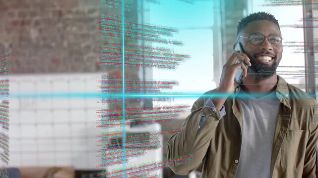 Tech pro speaking on smartphone in loft office, call starting activating cyan code overlay for work