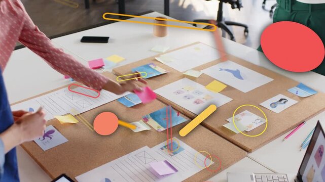 Planning team sorting mockups on table third joining with mug causing orange circles marking layout