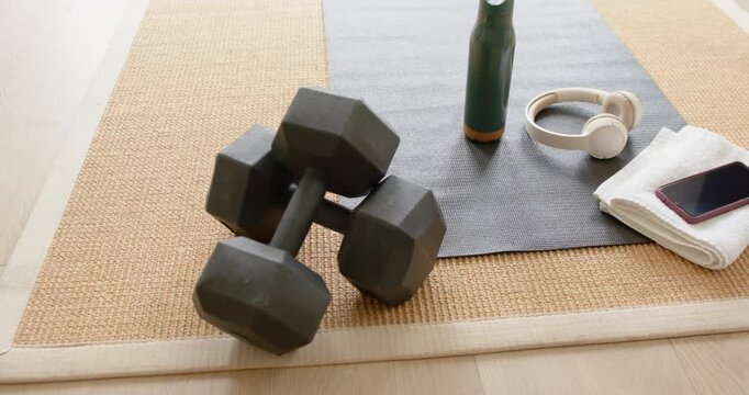 Camera is panning right and upward, revealing black hex dumbbells on mat for home workout prep