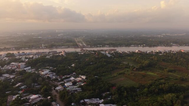 Vast Countryside Alongside Mekong. Aerial Perspective Over Can Tho At Dawn Shows Banks And River Bend. Sunrise Illuminates Broad Waterfront Town And Winding River Curves From Above