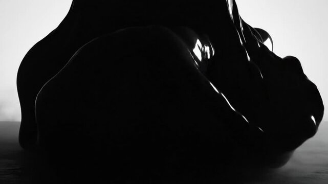 Abstract slow motion black liquid formation with reflections and smoky atmospheric effects